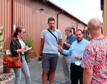 Group de personnes devant un bâtiment agricole